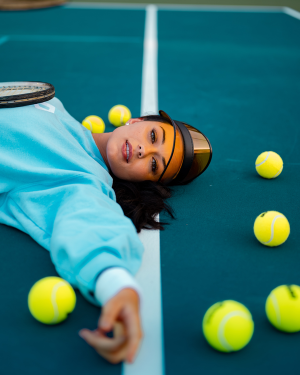 Tennis player laying down on tennis court
